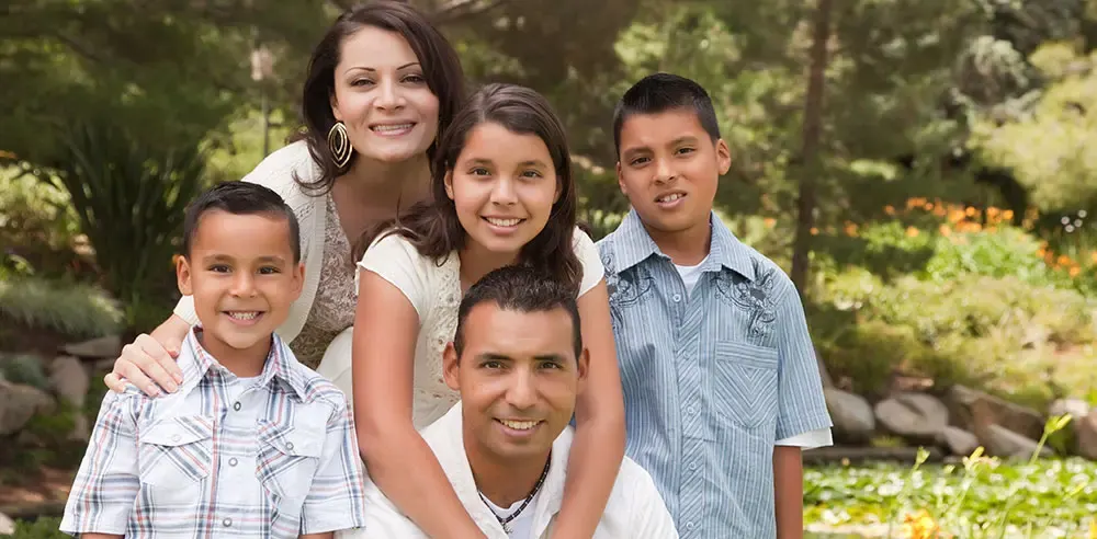Smiling family of five posing together outdoors