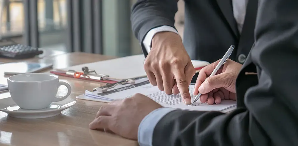 Professional reviewing and signing trust documents at a desk