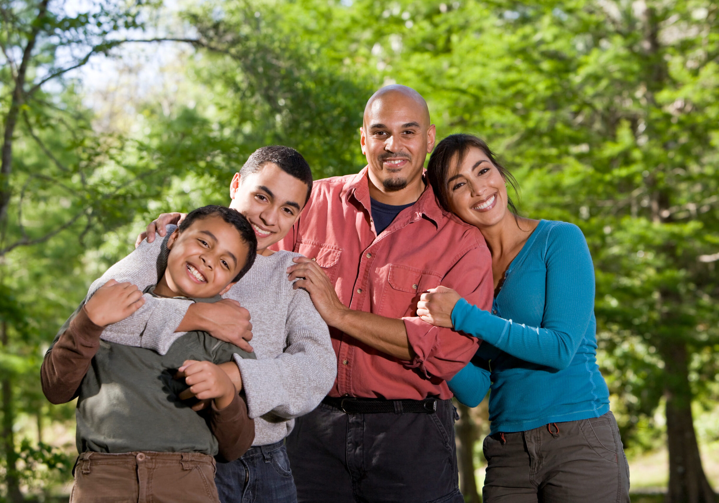 Portrait of Hispanic father and two boys outdoors in outdoor park